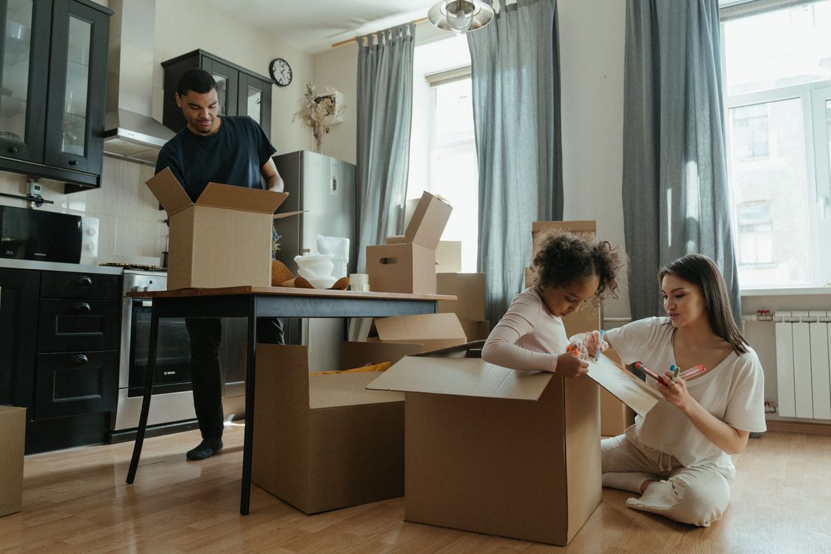 A family unpacking moving boxes in the kitchen of their new home