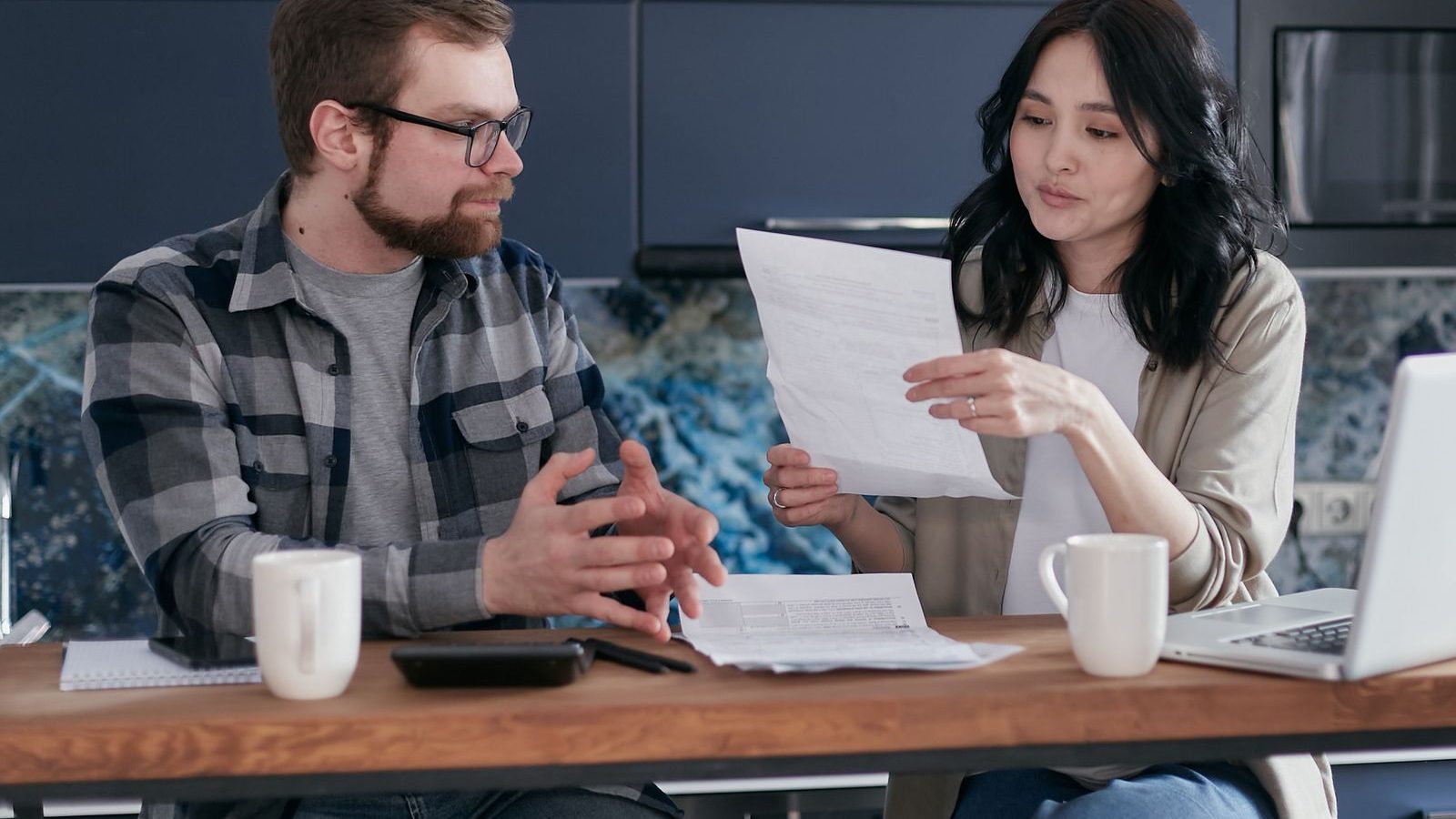 A couple reading through financial paperwork together at home