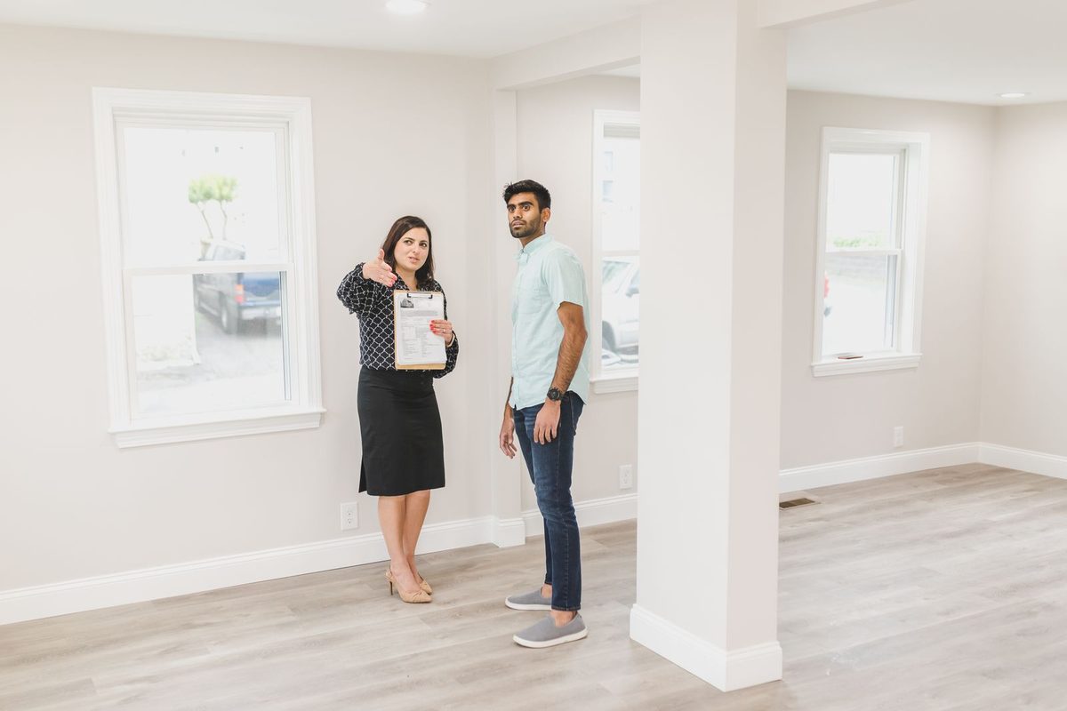Two people walking through an empty house during a showing