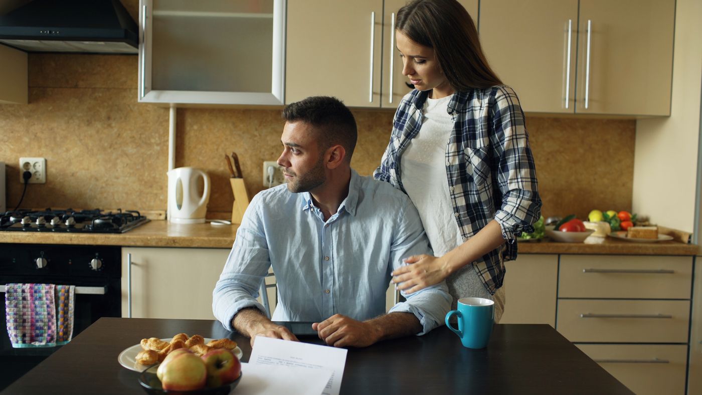 A couple reviewing bills and paperwork at their kitchen table