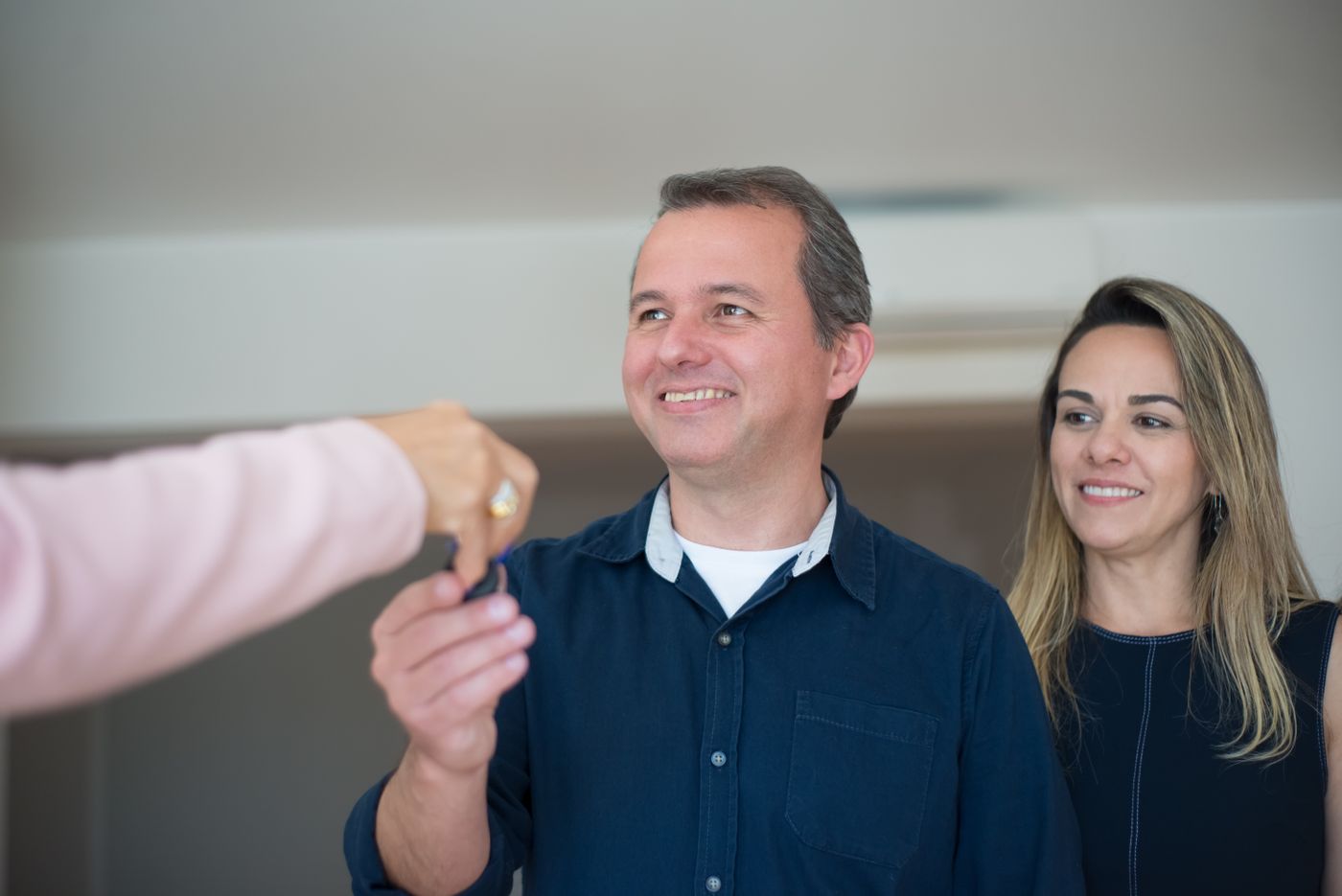 A couple smiling as they receive the keys to their home