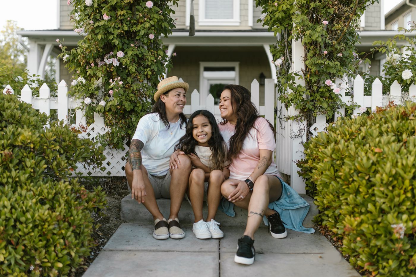 A family sitting together in front of their house