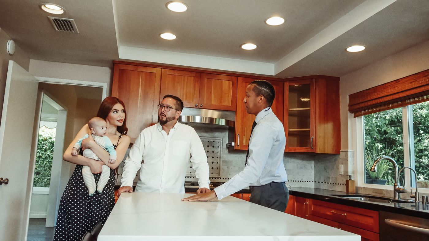 A family standing together in the kitchen of a home