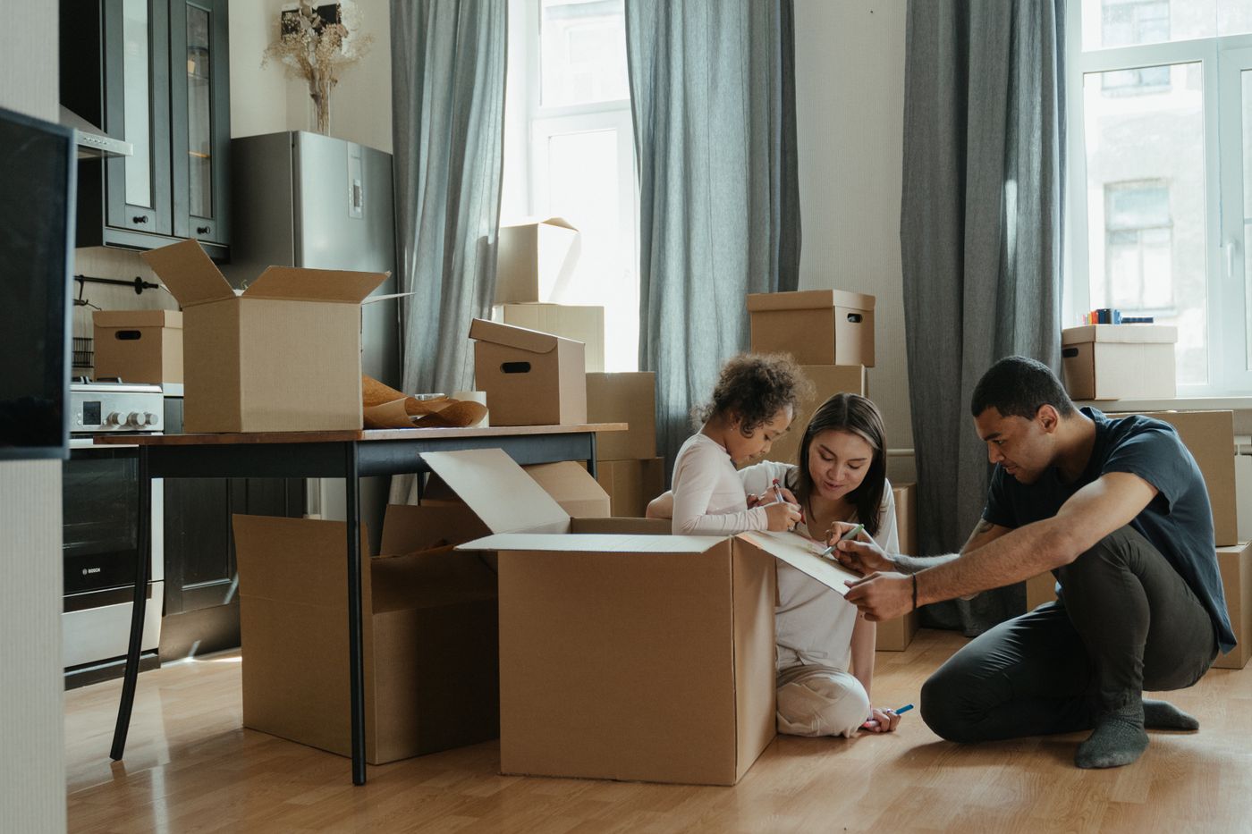 A family unpacking moving boxes in their new home